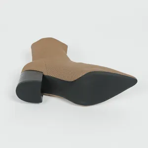 Detailansicht der beigefarbenen Strick-Stiefelette mit Blockabsatz und schwarzer Sohle