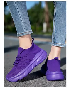 Purple fly-knit sock sneakers with thick soles shown walking on an outdoor asphalt road