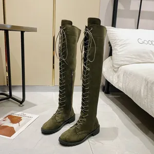 Dettaglio di stivali sopra il ginocchio in camoscio verde oliva stringati con zip e suola in gomma