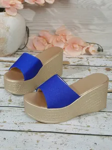 Détail de sandales à plateforme compensée en satin bleu royal avec semelles tressées or
