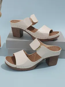 Gros plan sur des mules à talons épais matelassées beige pour femme