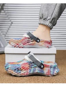 Close-up of tropical palm leaf print clogs with warm white faux fur lining