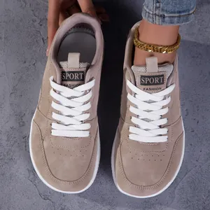 Vue détaillée des baskets rétro beiges à bout large avec lacets blancs et logo sport