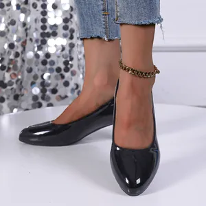 Close-up of elegant black patent leather pointed toe pumps with chunky heels