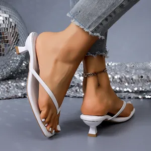 Close-up view of white kitten heel thong sandals with an elegant flip-flop design