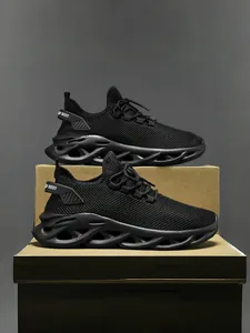Vista lateral de zapatillas de malla negra transpirable con suelas gruesas huecas