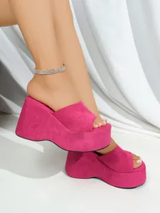 Close-up of hot pink fabric platform wedge sandals with elegant white background