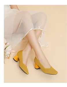 Detailed close-up of stylish yellow ribbed block heel pumps with elegant V-neck square toe.