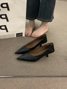Primer plano de tacones bajos de tejido negro con punta fina elegante