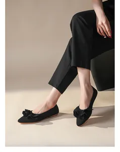 Nahaufnahme von eleganten schwarzen Strickschuhen mit spitzer Kappe und Rüschendetails vorne