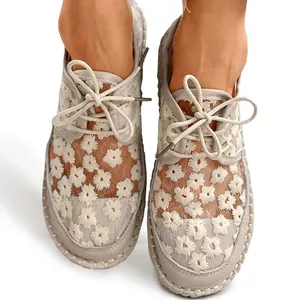 Close-up of women's mesh shoes featuring delicate daisy embroidery and lace-up detail