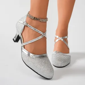 Nahaufnahme silberner Glitzer-Lateintanzschuhe mit Kreuzriemen und mittlerem Absatz.