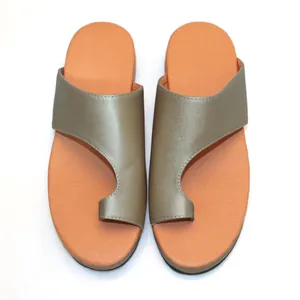 Detailweergave van modieuze damessandalen met teenring, bruine riempjes en oranje zolen