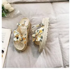Detailed view of trendy pineapple print platform sandals on a soft textured background