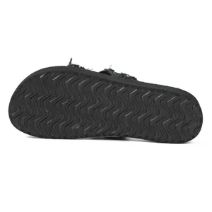 Nahaufnahme der schwarzen, wellenförmigen, rutschfesten Gummisohle von Denim-Sandalen.