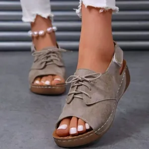 Detailed close-up of women's peep-toe lace-up platform sandals in khaki suede