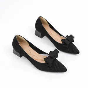 Detailed view of elegant black knitted pointed toe shoes with removable bow accessories
