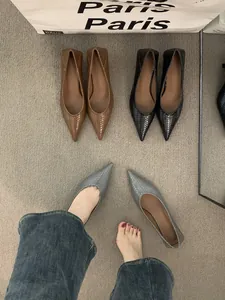 Vista detallada de los zapatos de mujer con punta tejida y tacón bajo en color marrón, negro y gris