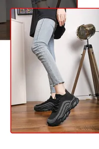 Close-up of black breathable knit sneakers with thick soles worn indoors