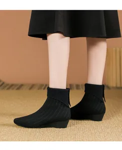Dettaglio degli stivaletti in maglia nera a punta da donna con design a zeppa elegante