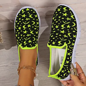 Primer plano de los zapatos sin cordones para mujer con patrón de estrellas y lunas