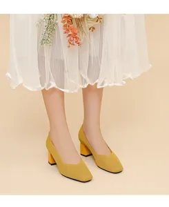 Detailed view of yellow ribbed knit block heel pumps with V-cut opening and square toe