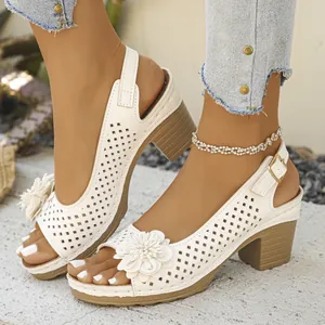 Close-up of white flower detail and perforated pattern on chunky heel sandals.