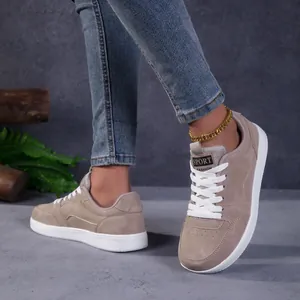 Détail de baskets kaki tendance à bout large portées avec un jean denim et une chevillère