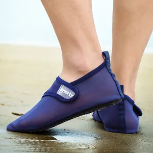 Close-up of blue mesh quick-dry water shoes on sandy beach with sports logo strap
