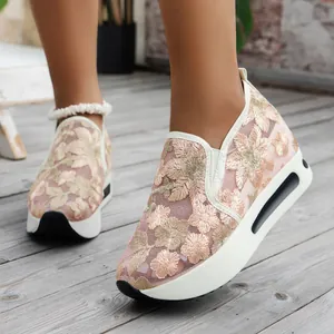 Close-up view of elegant floral embroidered mesh platform sneakers with sequin detail.