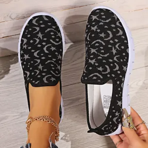 Primer plano de mocasines de flyknit negro transpirable con estampado de luna y estrellas