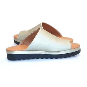 Zijaanzicht van elegante gouden plateau-slippers met dikke zwarte zool voor dames