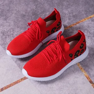 Side view detail of red knit mesh sneakers featuring leopard print and white soles