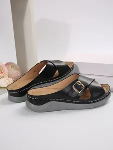 Elegant black women's cross-strap slide sandals with thick soles and gold buckle detail