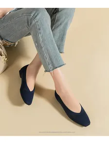 Close-up of stylish navy blue knitted square-toe flats for women paired with denim jeans