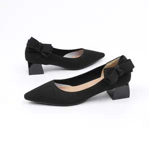 Detailed view of removable black knit bow shoe ornaments on pointed-toe shoes