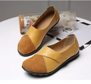 Detaillierte Makroaufnahme der gelben und braunen Leder-Patchwork-Slipper für Damen