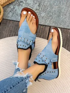 Detailed view of stylish denim flip-flop sandals with metal rivets and back zipper.