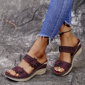 Detail view of purple wedge sandals featuring floral accents and rhinestone embellishments.