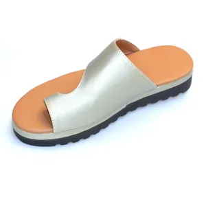 Detailweergave van de champagne metallic plateausandaal voor dames met teenlus en bruin voetbed