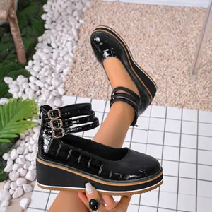 Vue détaillée de chaussures compensées en vernis noir à motif croco avec triple bride.