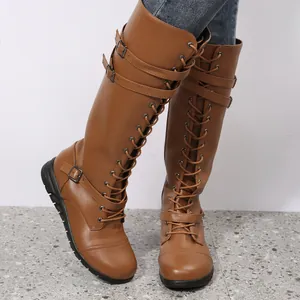 Brown knee-high lace-up boots with buckle straps and round toe design