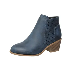Close-up detail of blue faux suede ankle boots with laser-cut floral patterns and block heel