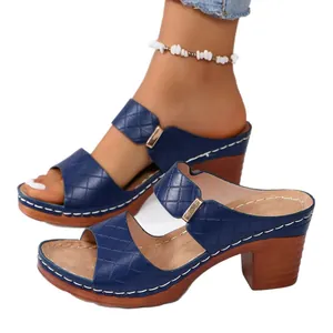 Sandales à talons blocs bleues avec motif en croix et semelle compensée en bois.