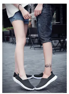 Close-up of a couple wearing matching black breathable woven loafers with white soles