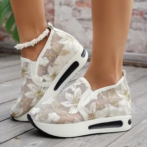 Close-up of breathable white mesh platform shoes with floral embroidery and sequins