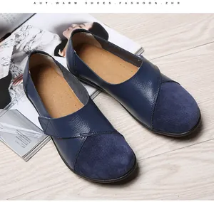 Elegante marineblaue Leder- und Wildleder-Loafers für Damen auf Holzuntergrund
