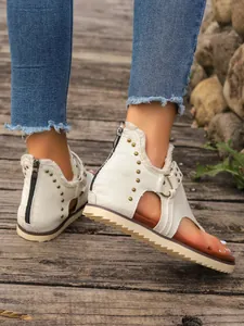 Close-up of off-white canvas thong sandals with rivets and back zipper for summer.