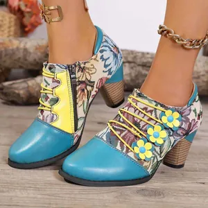 Detail view of ethnic floral ankle boots with blue leather toe and chunky stacked heel.