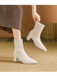 Detail van beige gebreide enkellaarsjes met puntige neus en stevige blokhak